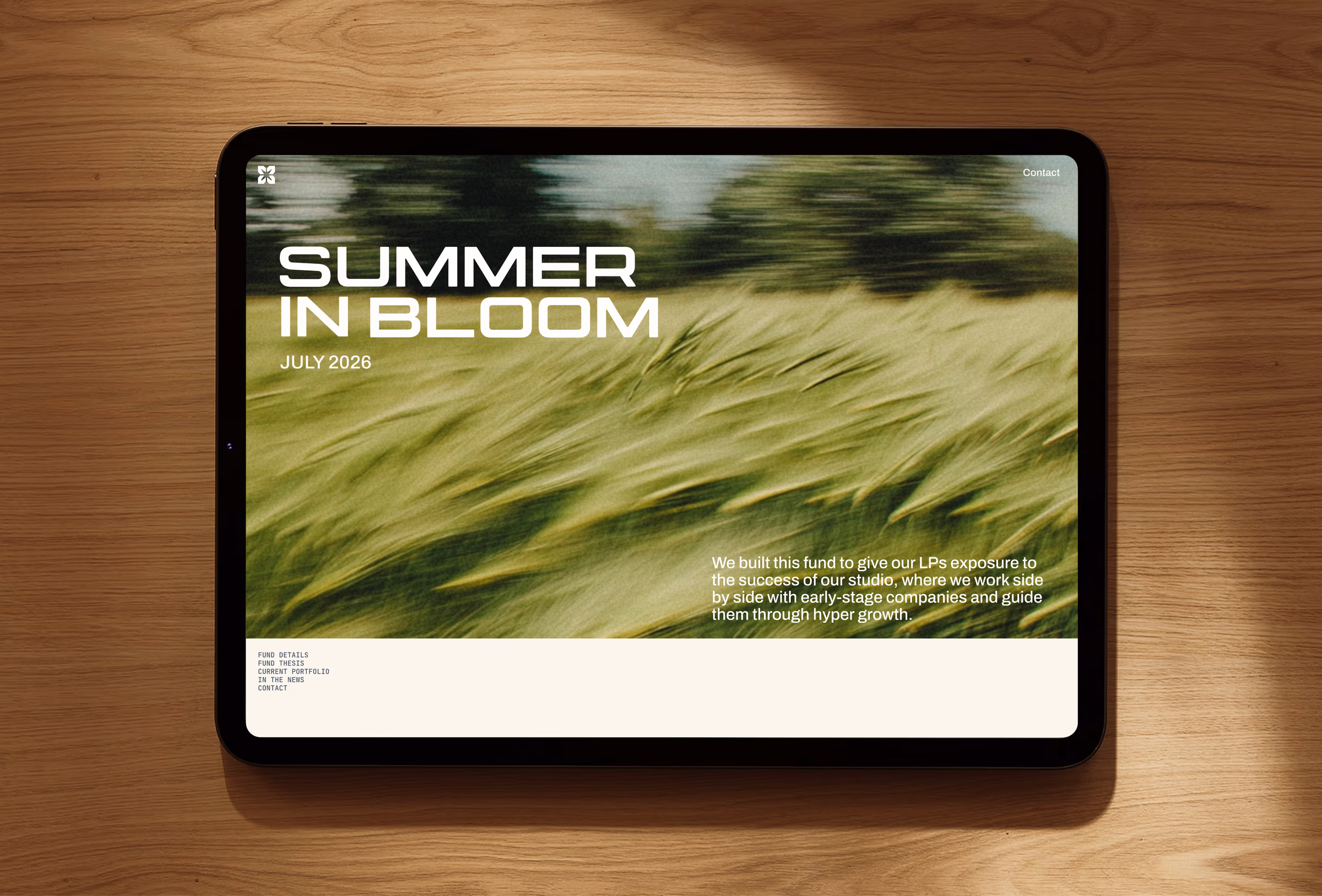 Tablet showing the Summer in Bloom fund microsite for July 2026 over motion-blurred field photography