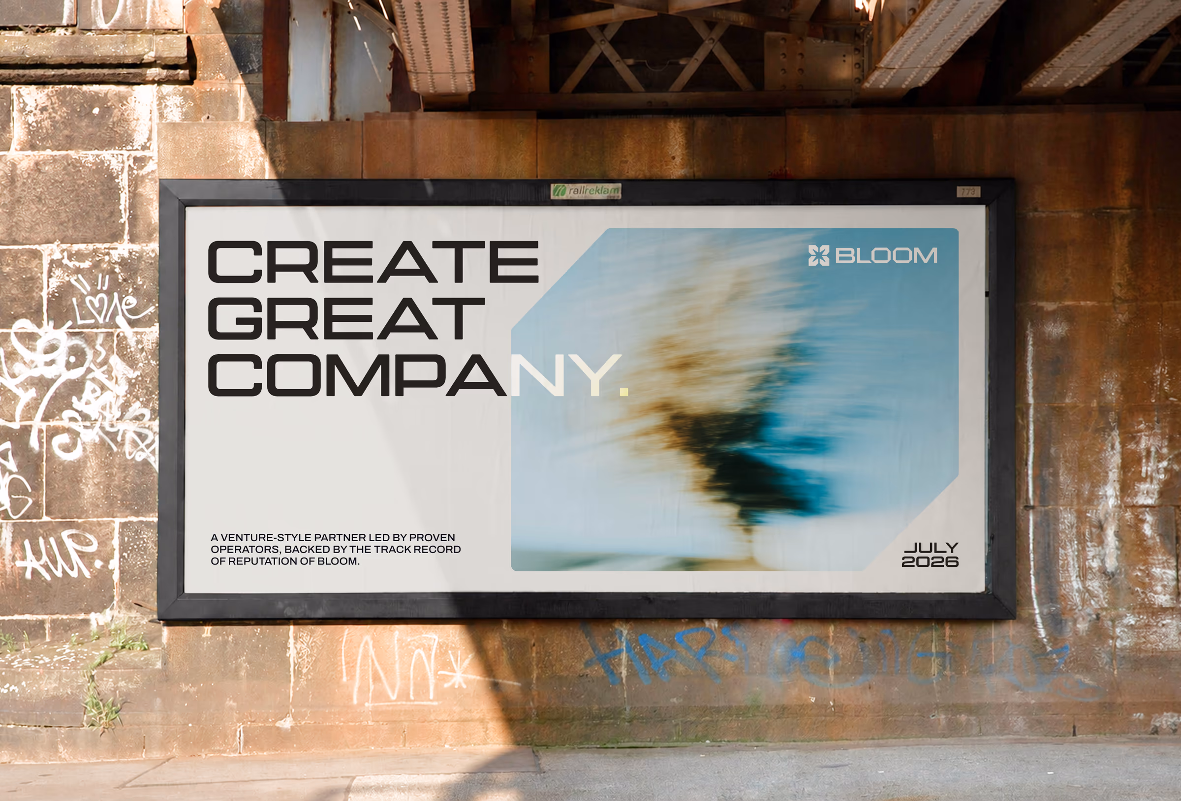 Billboard under a rail bridge reading Create great company beside motion-blurred photography in a chamfered frame
