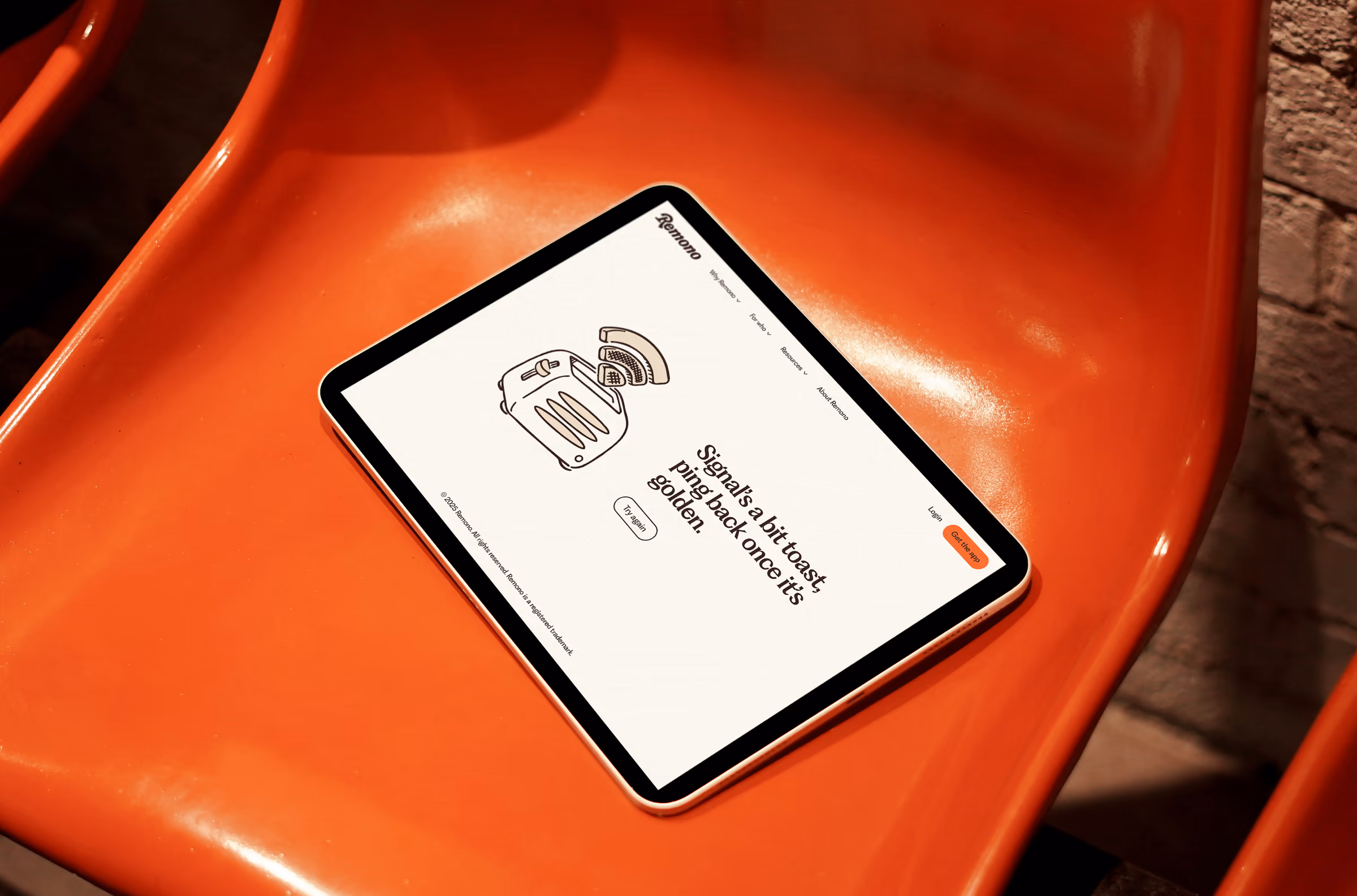 Tablet on an orange chair showing a Remono page with a toaster illustration