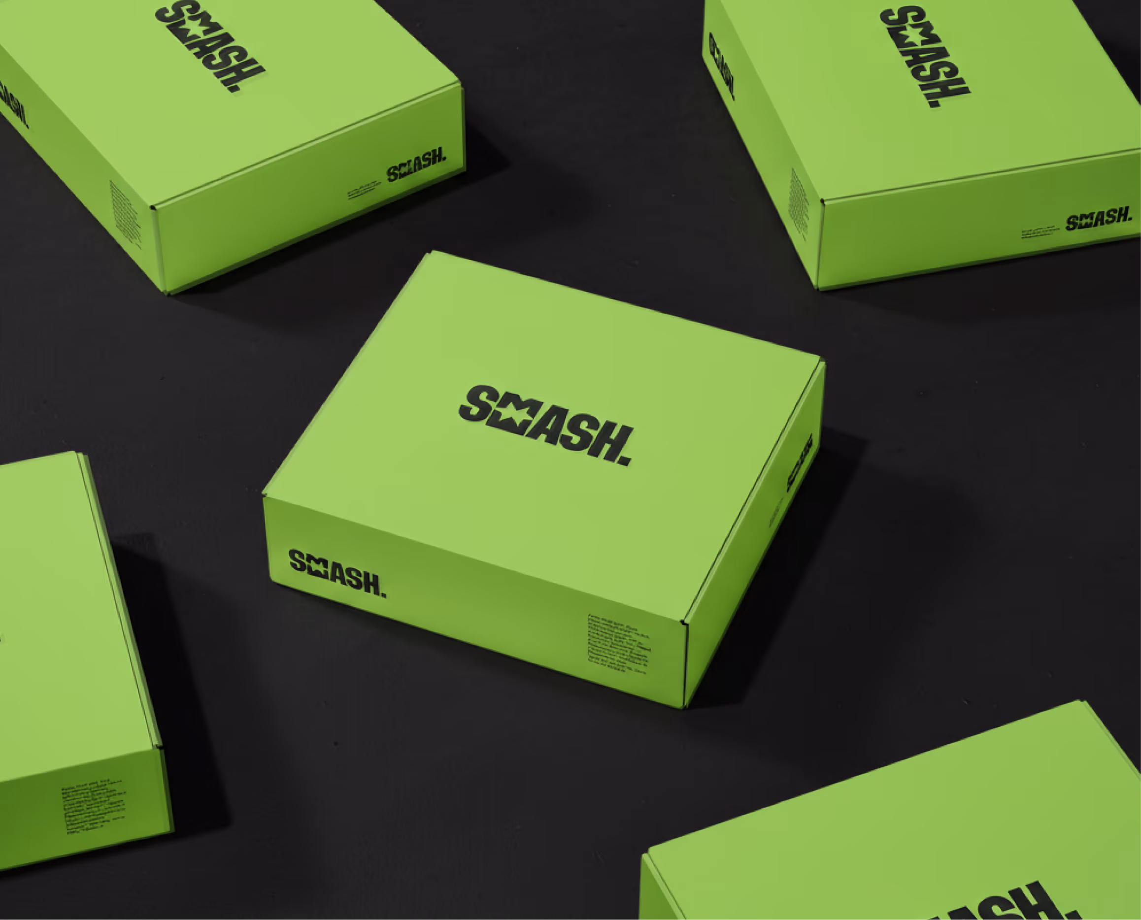 Bright green Smeash mailer boxes with black wordmarks scattered on a dark surface