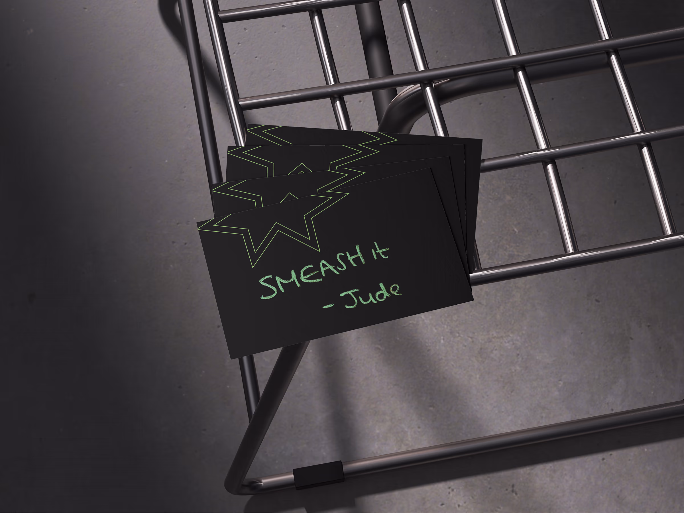 Stack of dark Smeash cards with handwritten SMEASH it, signed Jude, resting on a wire rack