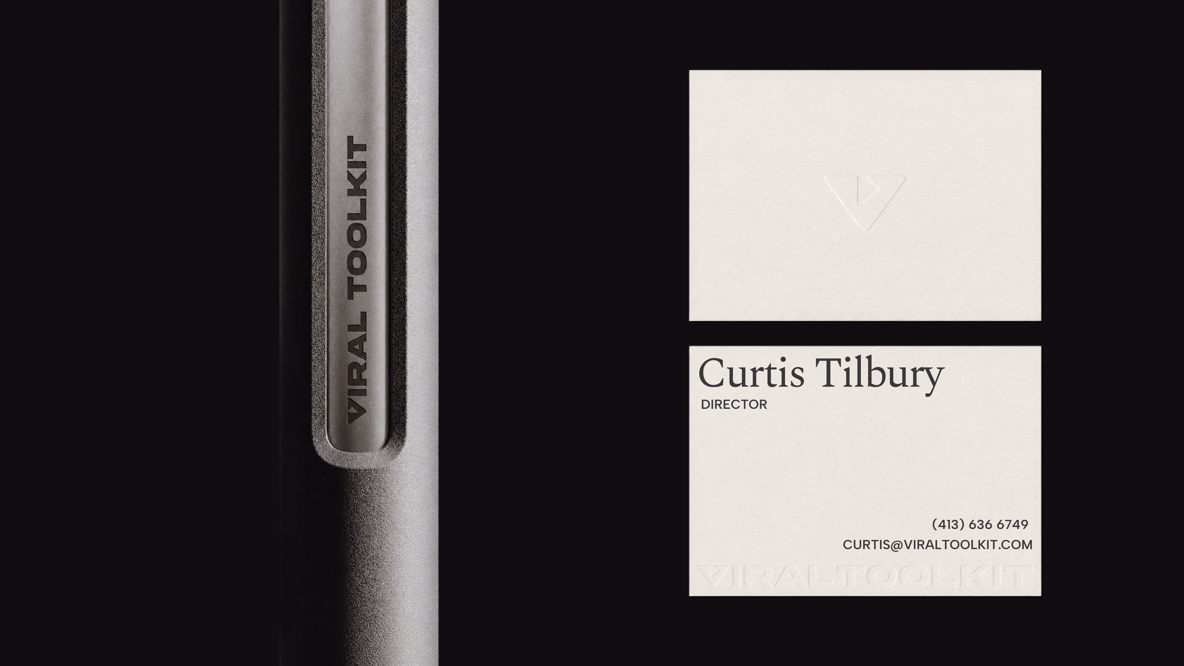 Engraved Viral Toolkit pen beside blind embossed business cards for director Curtis Tilbury