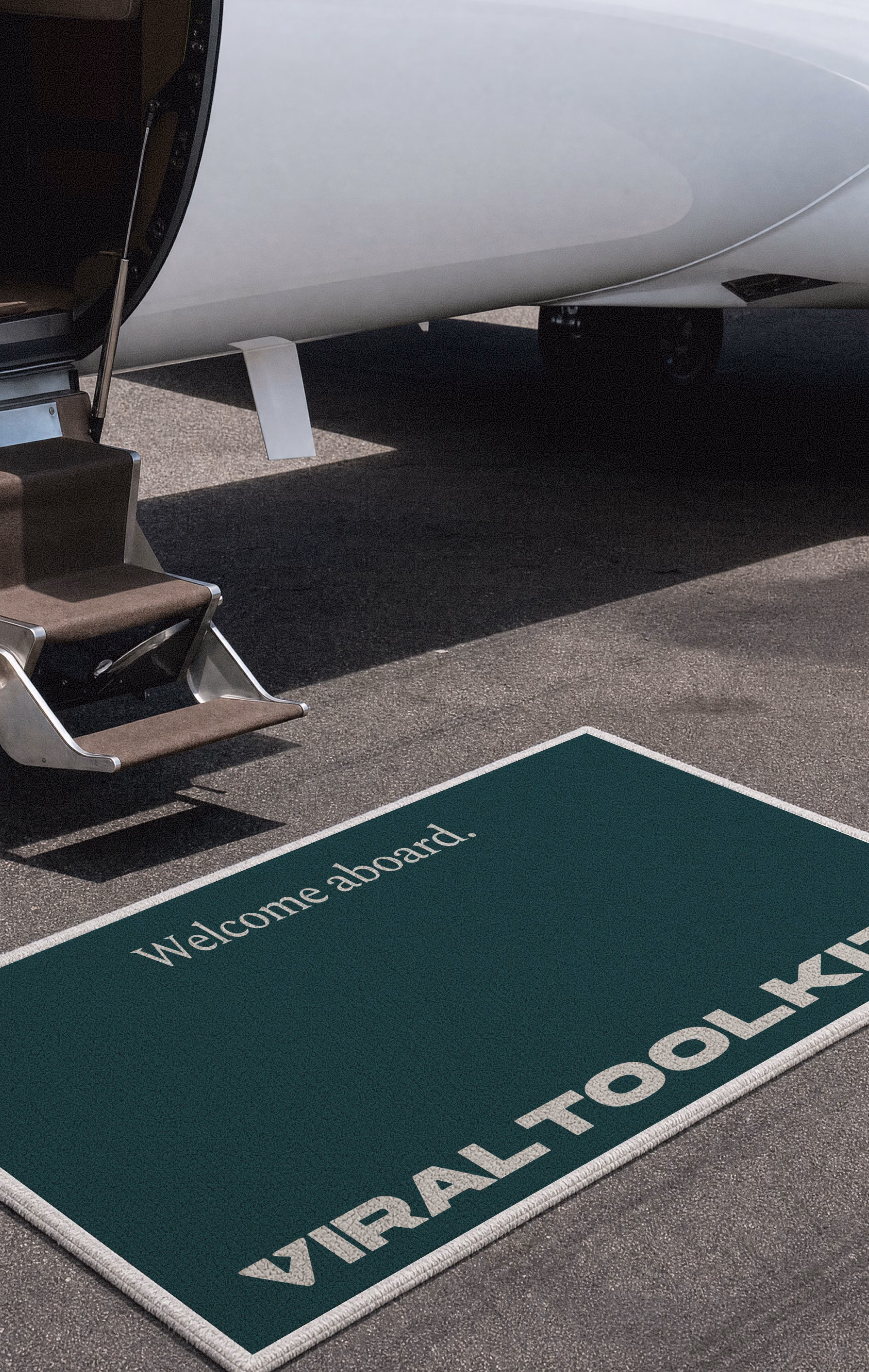 Dark green Welcome aboard mat at the steps of a private jet