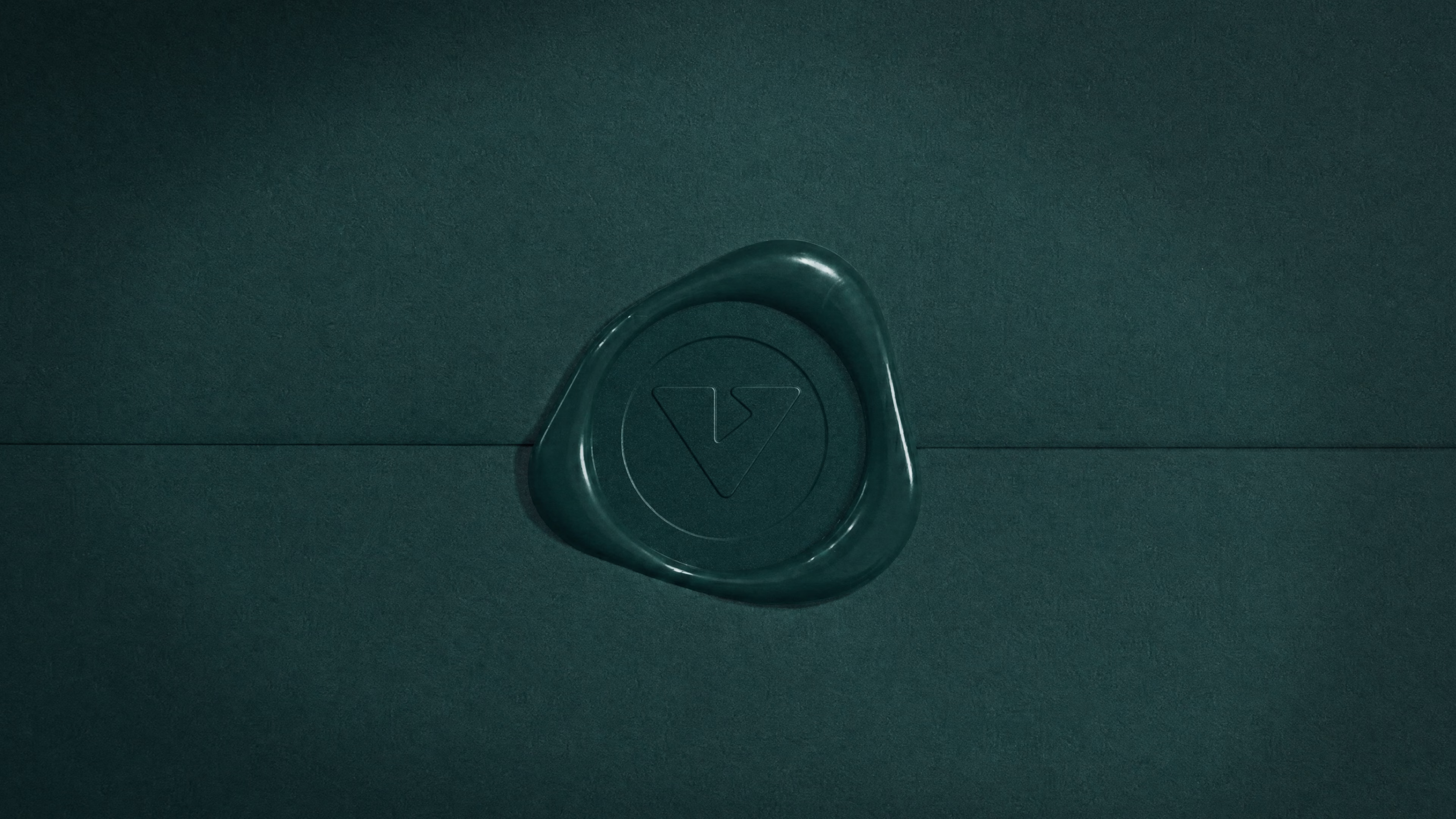 Dark green wax seal pressed with the V monogram on an envelope